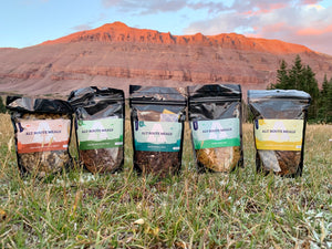 
                  
                    Small Detour Bundle. Meals standing in the grass. Backdrop is a beautiful red butte in the high Unita Wilderness.
                  
                