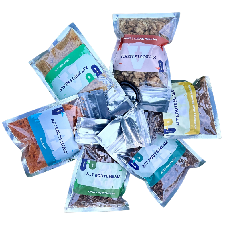 Alt Route Meals Sampler Pack is pictured from above. 6 Meals. 2 Breakfast. 4 Dinners. White Stock back drop.